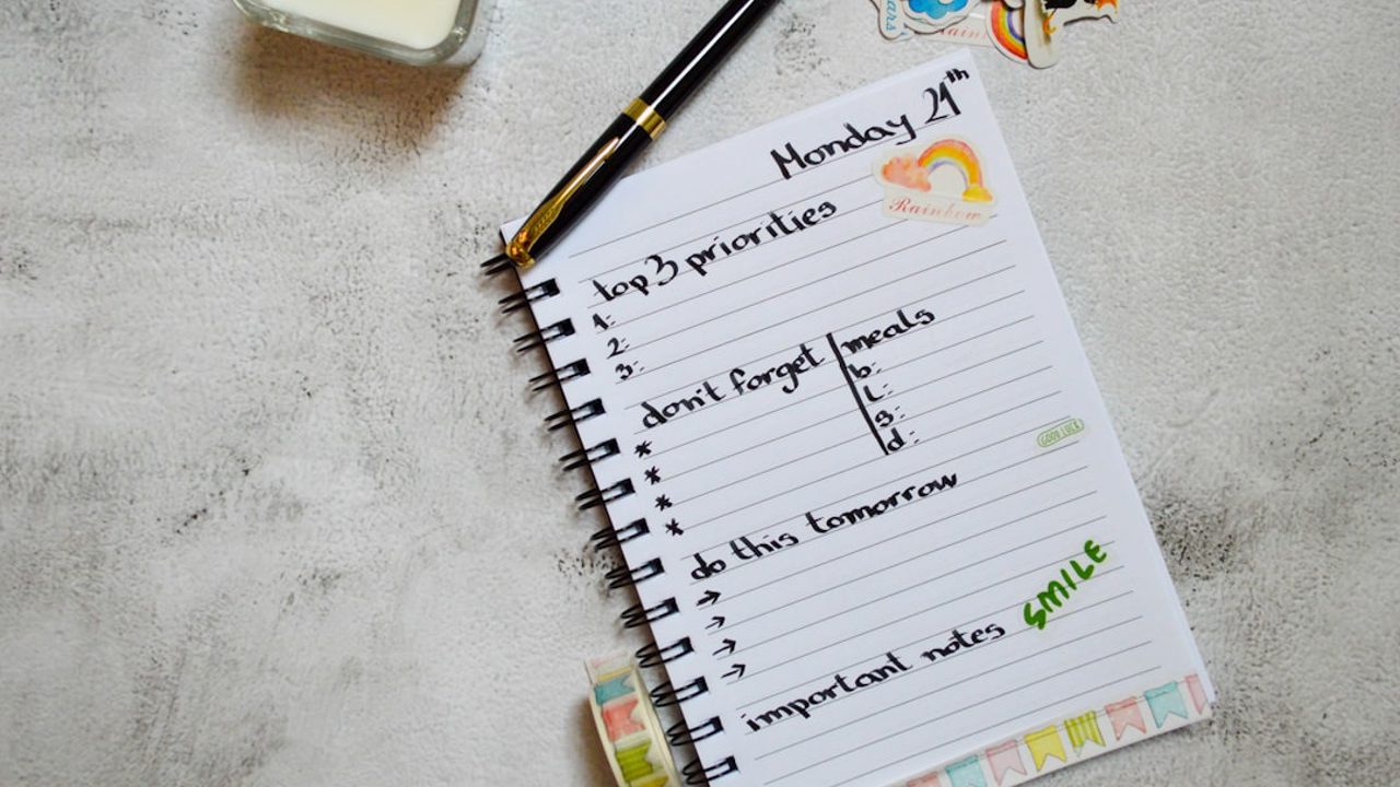 A flatlay shot of a planner with a pen, candle, stickers, and washi tape