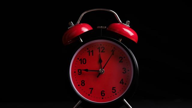 red alarm clock on a black background