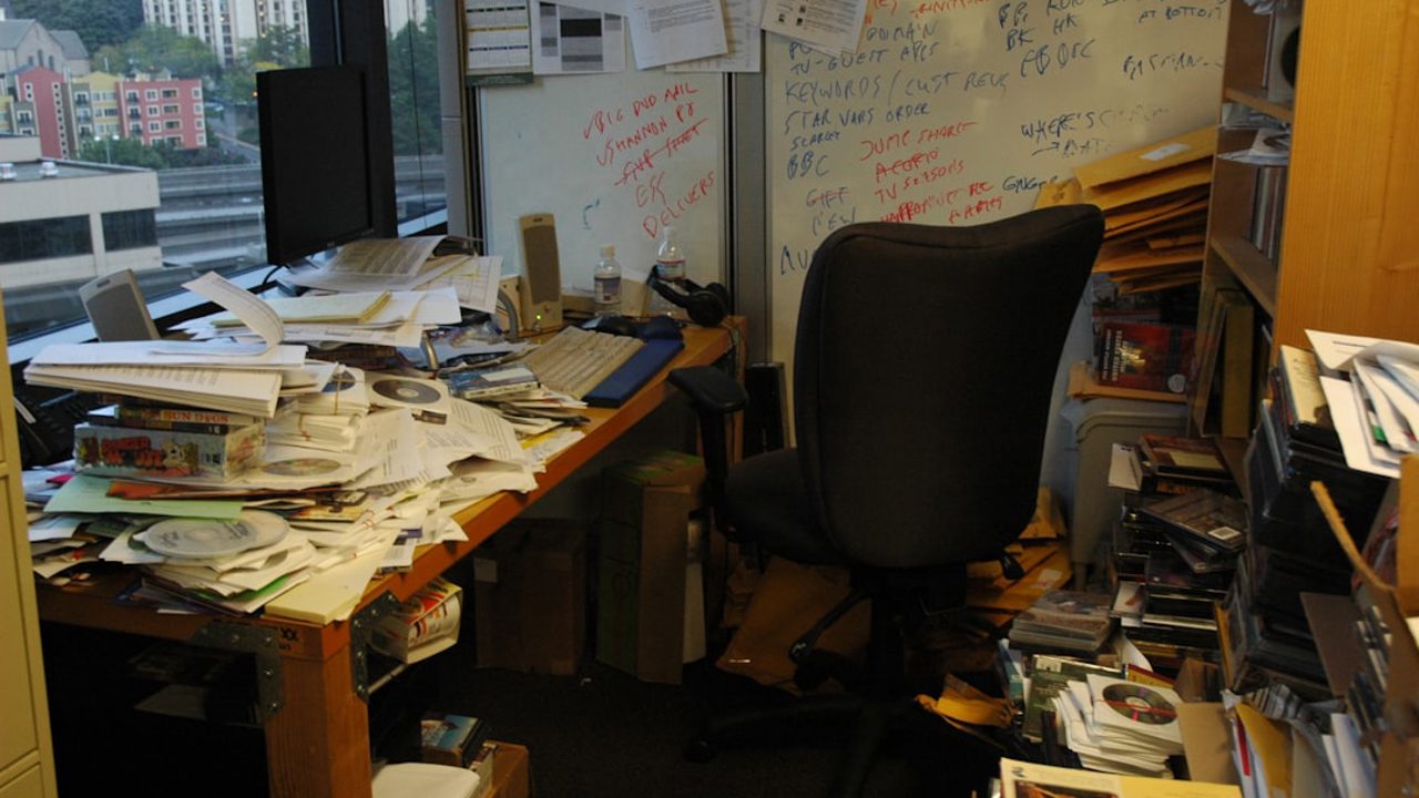 Office of a high-tech worker, whiteboard, notes, papers, plans, sample floppy disks, piled up, in stacks, reviews, keyboard, screen, notes, door, desk, speakers, old calendar, noodle cup, view, high-rise building, Seattle, Washington, USA

Active work area. This is not the messiest office I've ever seen. I once saw an office where papers went up the walls in a V shape—there was a path down the middle and 3 developers worked there. But I couldn't photograph it. From time to time they threw away their notes, papers, books, etc. Leave a dollar if you want https://paypal.me/1drlane
wonderlane@gmail.com