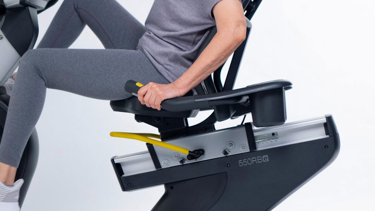 Mature, active senior female cyclist exercises on a 550 RBe Recumbent Bike.